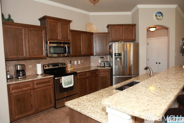 A kitchen with wooden cabinets and granite countertops.