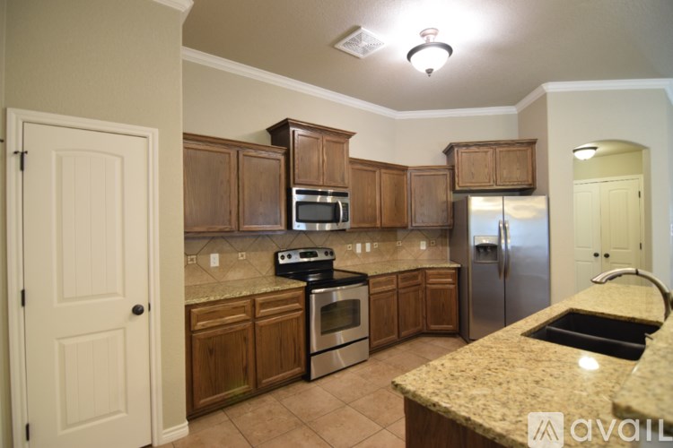 A bedroom with a bed, a chair, a table, and a fan.