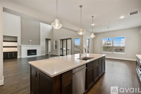 A modern kitchen with dark wood cabinets and a large island.