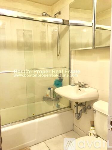 A bathroom with a glass shower door and a white sink.