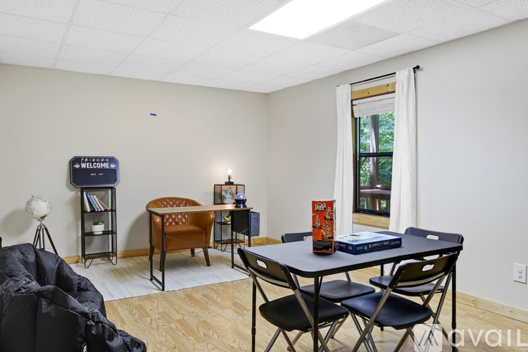 A room with a table, chairs, and a bookshelf.