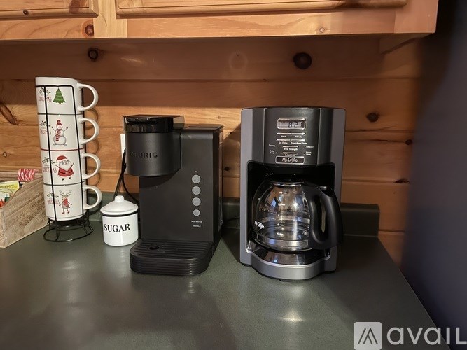 A coffee maker and a sugar dispenser are on a countertop.