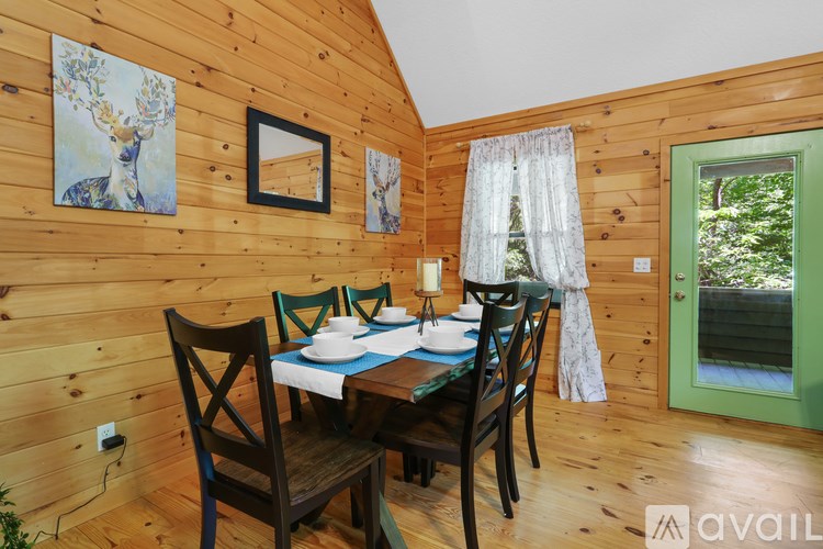 A wooden table with chairs and a painting of a deer on the wall.