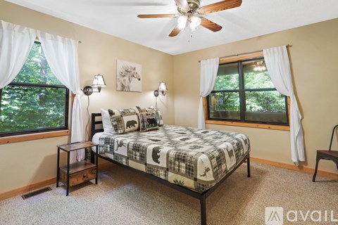 A bedroom with a bed, nightstand, and window.
