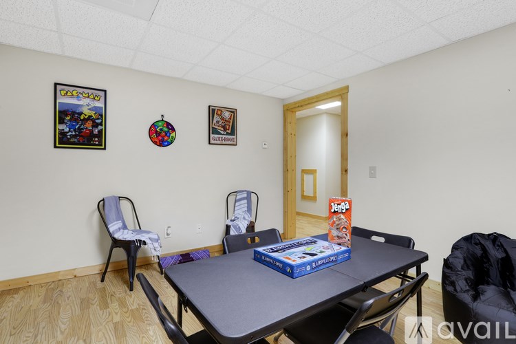 A room with a table, chairs, and pictures on the wall.