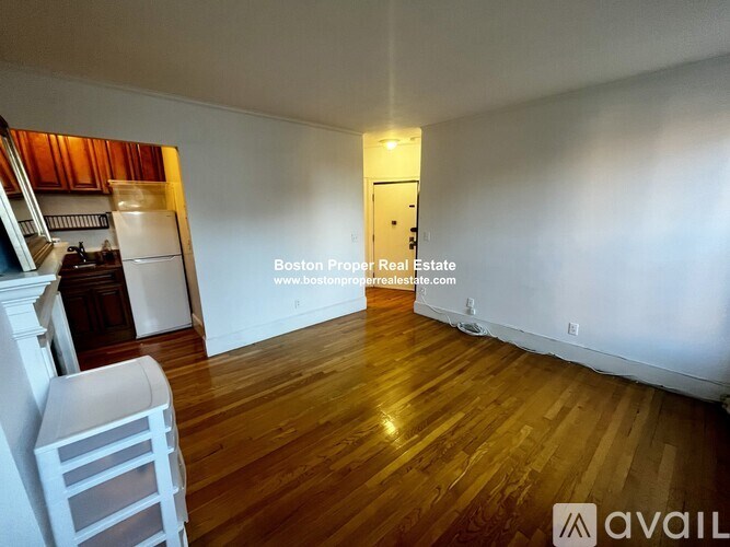 A room with wooden floors and a white chair in it.