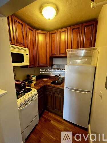 A kitchen with wooden cabinets and a white refrigerator.
