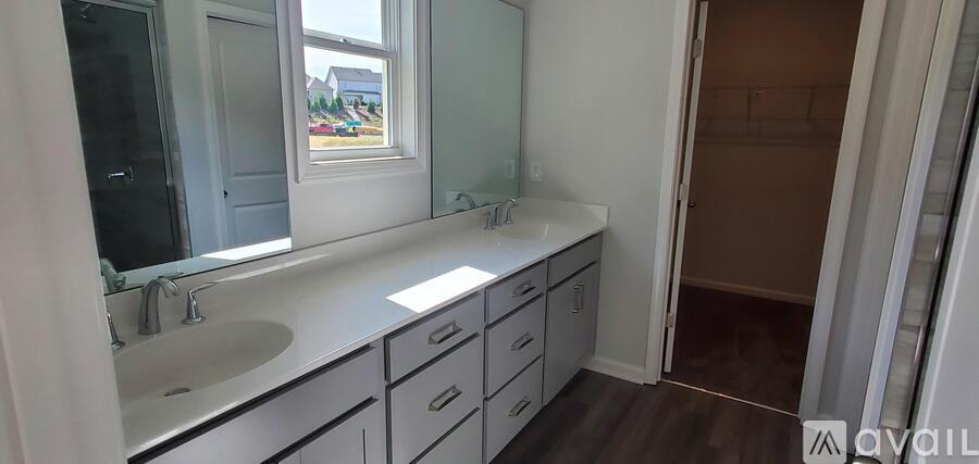 A bathroom with a sink, mirror, and a window.