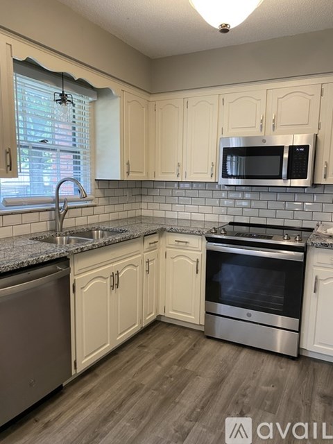 A kitchen with wooden cabinets and a stainless steel oven.