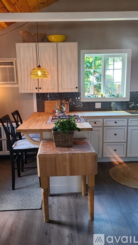 A kitchen with a table and chairs.