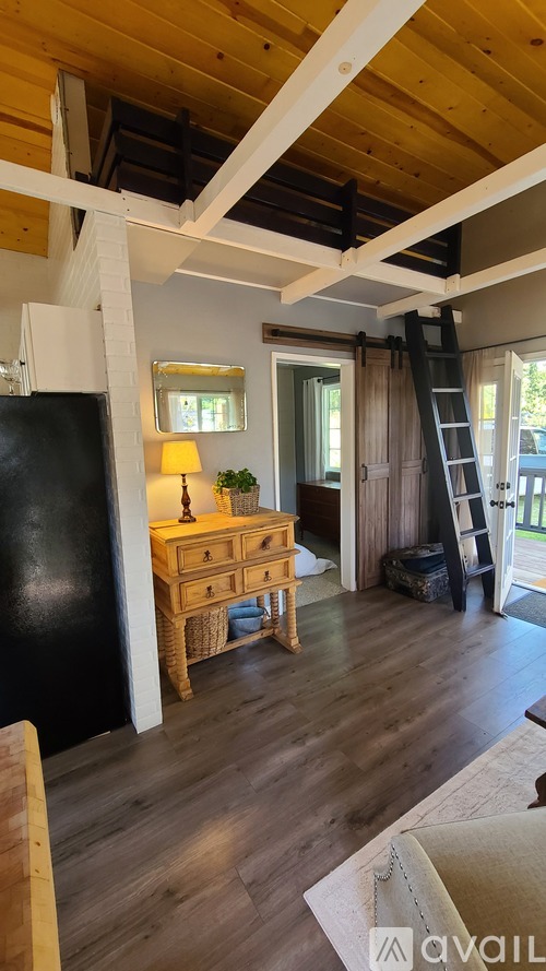 A room with wooden floors and a black door.
