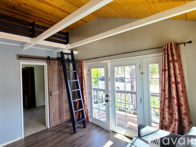 A room with a wooden ceiling and a ladder.