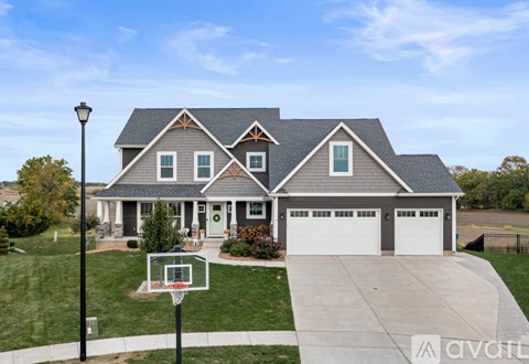 A house with a basketball hoop in front.