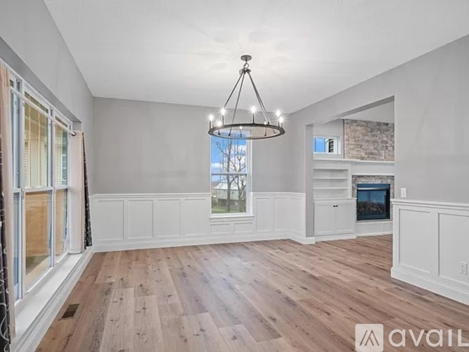 A spacious living room with wooden floors and a chandelier.