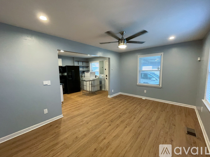 A room with a ceiling fan and wooden flooring.