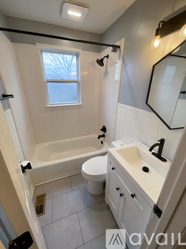 A bathroom with a white tub, sink, and toilet.