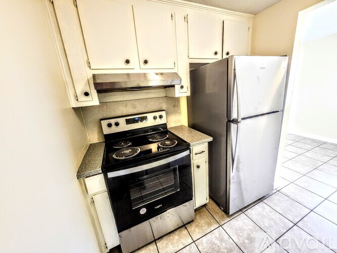 A kitchen with a stove and refrigerator.