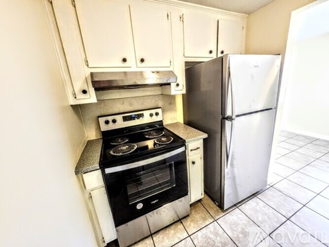 A kitchen with a stove and refrigerator.