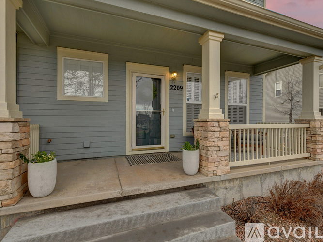 A house with a front porch and a door with the number 2209 on it.