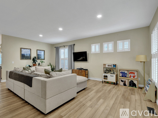 A spacious bedroom with a large bed and a TV on the wall.