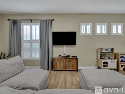 A living room with a grey sofa and a wooden cabinet.