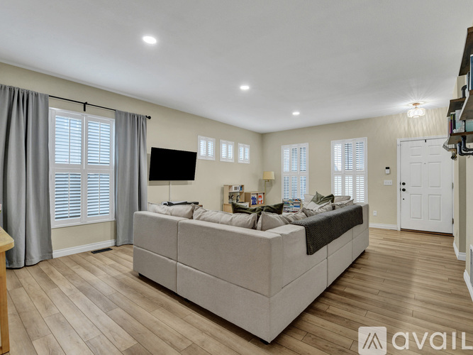 A spacious living room with a large couch and a television.