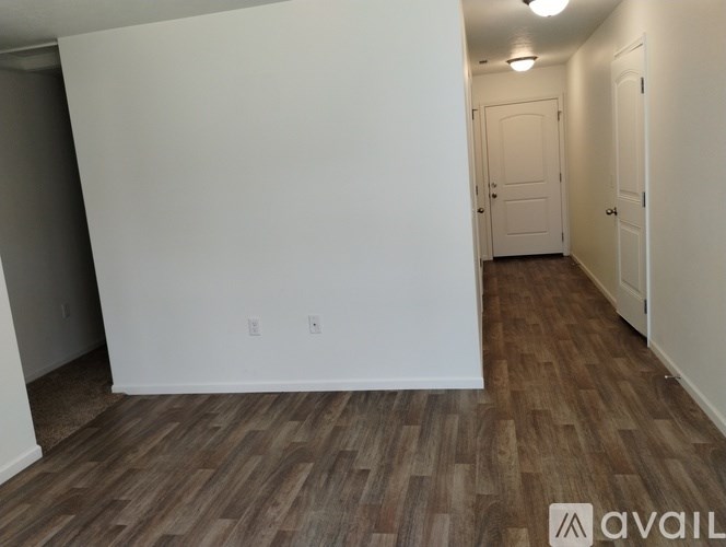 A room with wooden flooring and white walls.