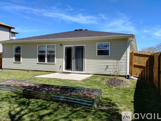 A house with a grey siding and a brown fence.