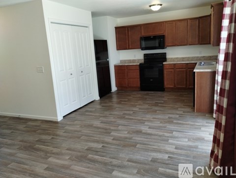 A kitchen with wooden cabinets and a black oven.