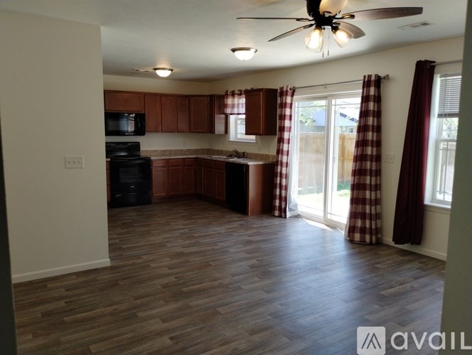 A kitchen with wooden floors and a ceiling fan.