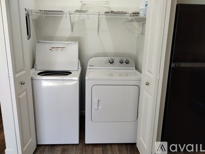 A small white washer and dryer are in a small laundry room.