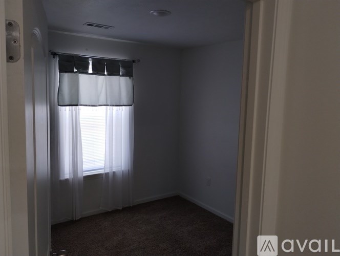 A room with a window covered by a white curtain.