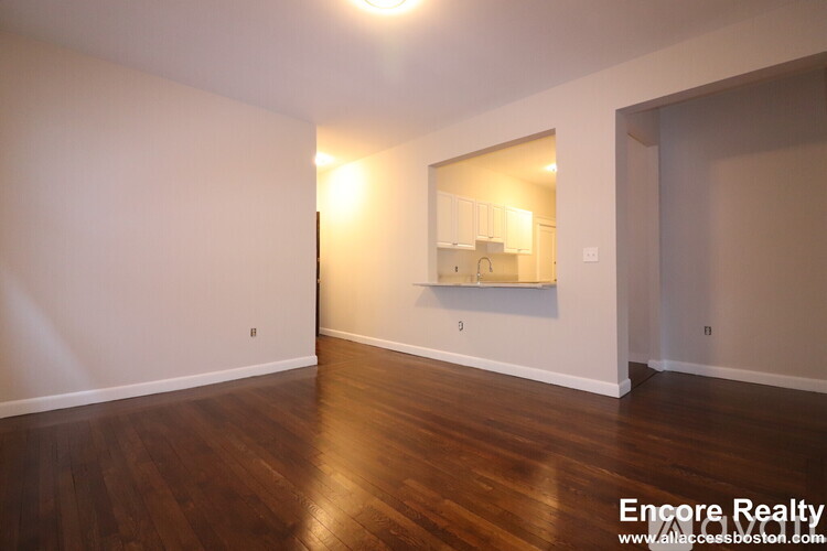A room with wooden floors and a mirror on the wall.