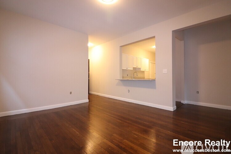 A room with wooden floors and a mirror on the wall.