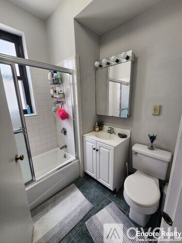 A white bathroom with a toilet, sink, and tub.