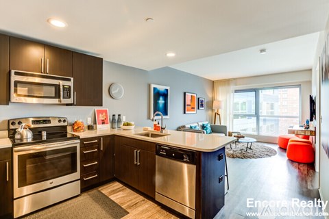 A modern kitchen with stainless steel appliances and wooden cabinets.
