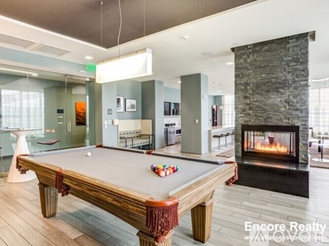 A pool table in a room with a fireplace.