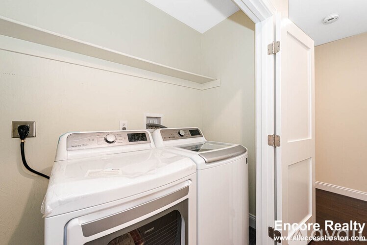 A white dryer and washer in a small laundry room.