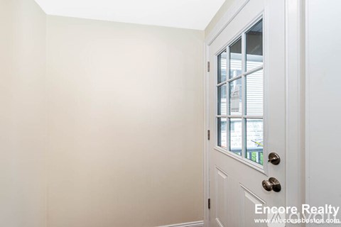 A white door with a window and blinds is closed.