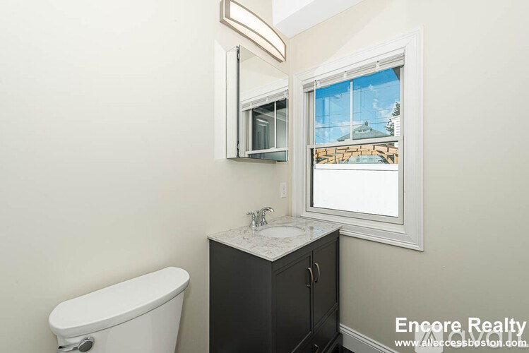 A white toilet sits next to a sink in a bathroom.