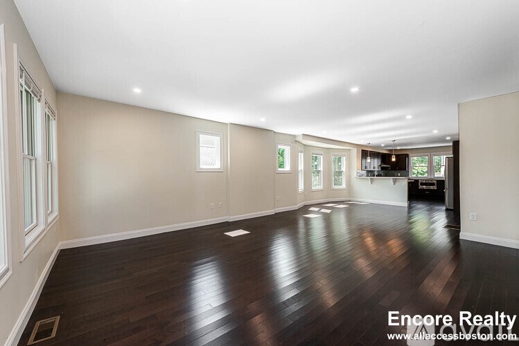 A spacious room with wooden floors and white walls.