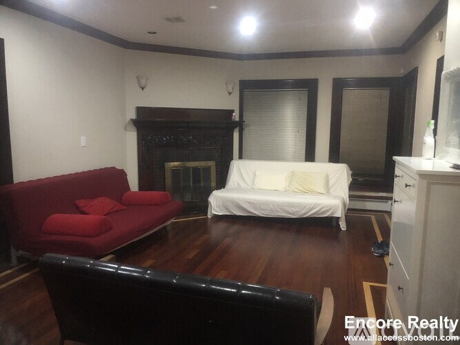 A living room with a red couch and a white sofa.