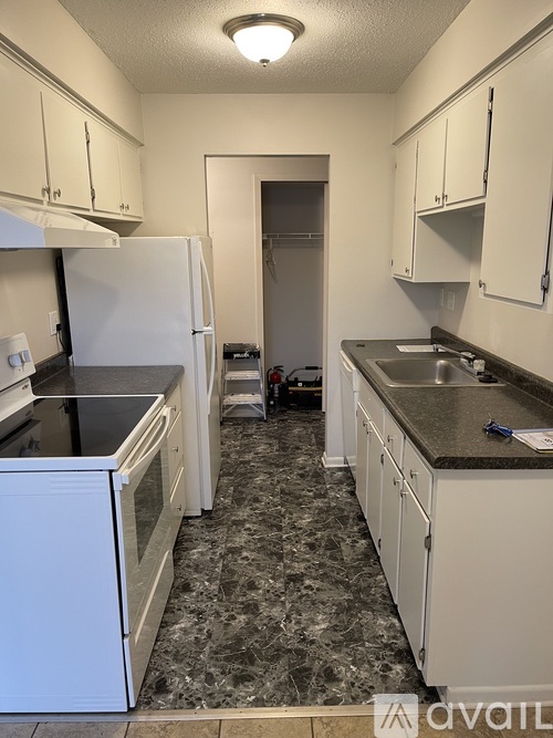 A kitchen with white appliances and cabinets.