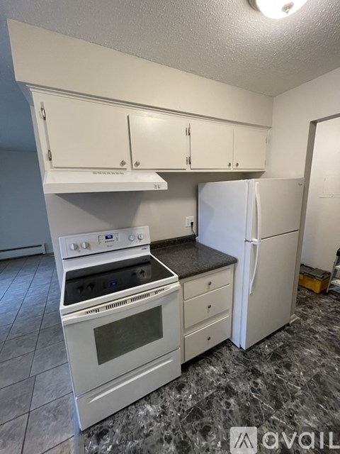 A kitchen with a white oven and refrigerator.