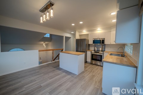 A modern kitchen with a stainless steel oven and a wooden floor.