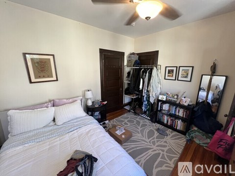 A bedroom with a large bed and a ceiling fan.
