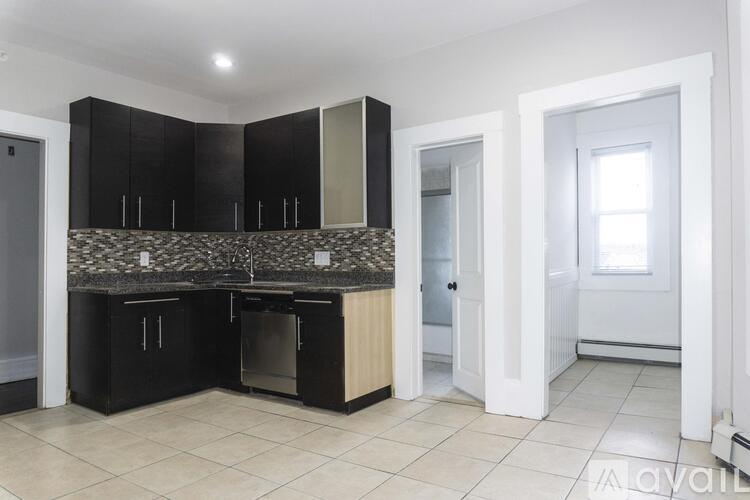 A kitchen with black cabinets and a granite countertop.