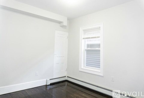 A room with a white door and a window with blinds.