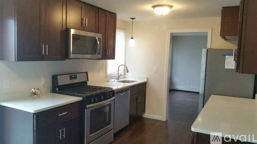 A kitchen with dark wood cabinets and stainless steel appliances.
