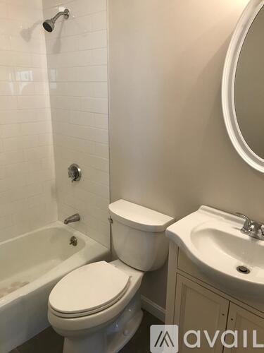 A white toilet sits next to a white sink in a bathroom.